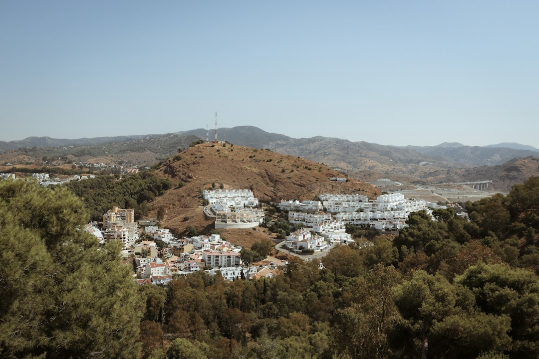 Sunlit white buildings among green hills in the Axarquía region of Andalusia