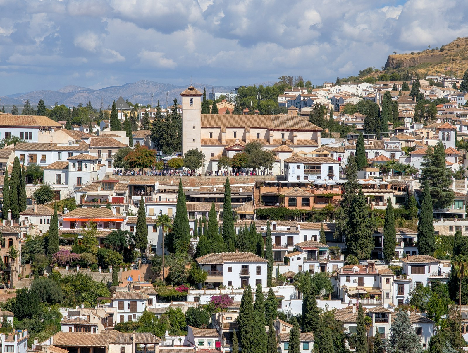 Whitewashed Andalusian buildings among hillside greenery near Baza