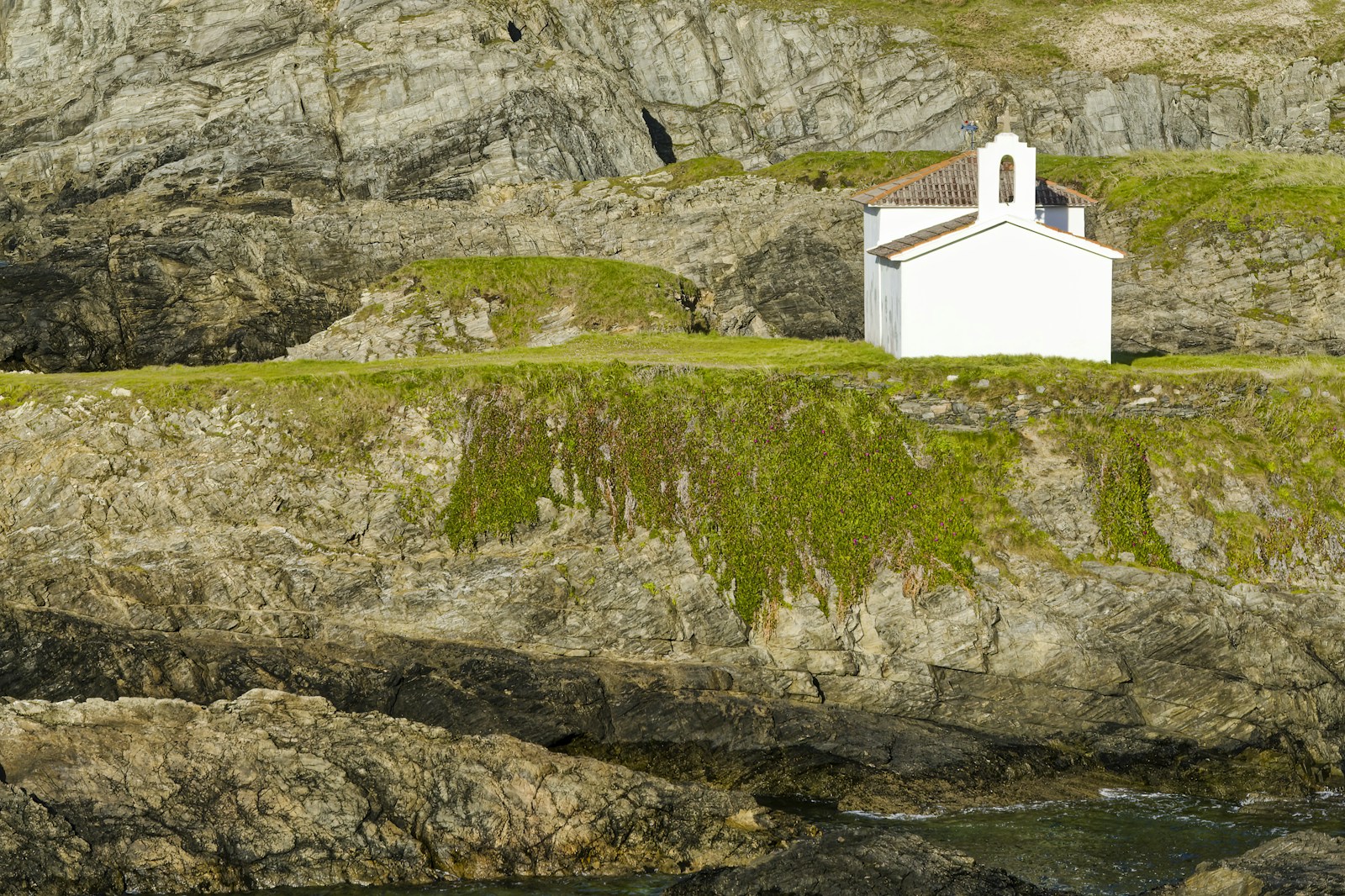 White chapel on a rocky Spanish coastline